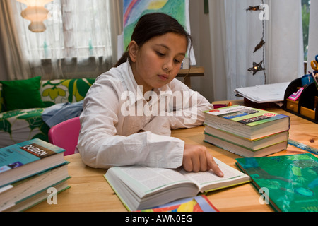 Jeune écolière faire leurs devoirs en pépinière, reading book Banque D'Images