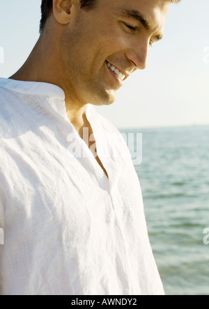 Man smiling, mer en arrière-plan Banque D'Images