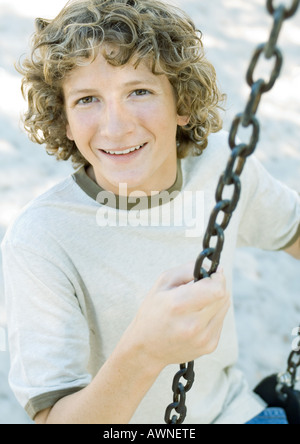 Preteen boy on swing Banque D'Images