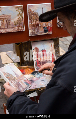 France Paris Butte Montmartre, Place du Tertre peintre à travailler sur vue typique de Paris avec peintures sur chevalet dans bkgd Banque D'Images