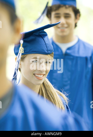 Diplômés en ligne, smiling, focus on young woman Banque D'Images