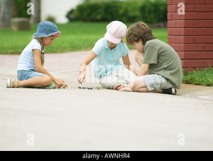 Enfants jouant aux billes dans Street Banque D'Images