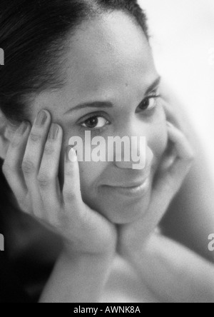 Femme tenant le visage avec les mains, close-up, B&W. Banque D'Images