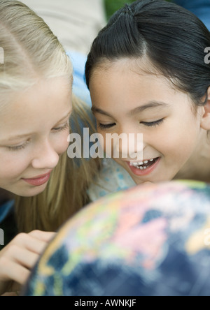 Girls looking at globe Banque D'Images