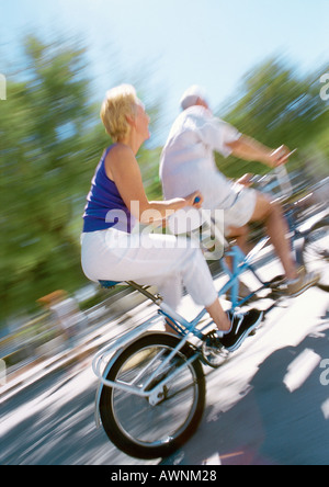 Man and Woman riding ensemble sur tandem, blurred Banque D'Images