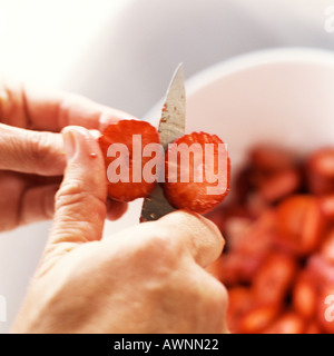 Les mains de trancher les fraises, close-up Banque D'Images