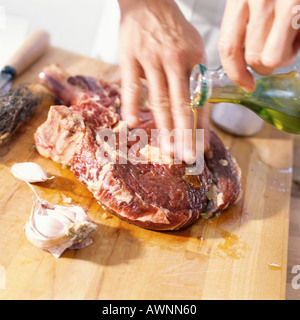 Close-up of ribeye steak en préparation avec de l'huile Banque D'Images