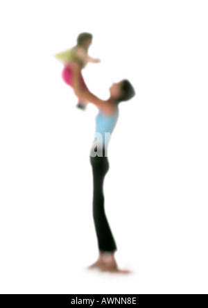 Silhouette of woman holding up enfant dans l'air, sur fond blanc, defocused Banque D'Images