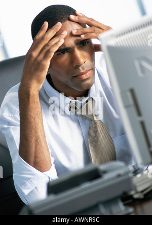 Businessman holding head in hands Banque D'Images