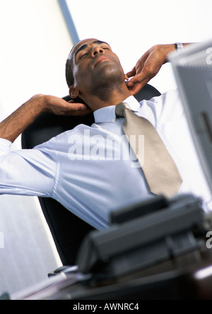 Businessman stretching en fauteuil Banque D'Images