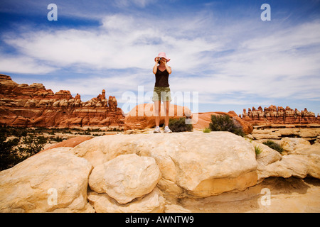 Les touristes à la recherche sur des formations rocheuses, Moab, Canyonlands, Utah, United States Banque D'Images