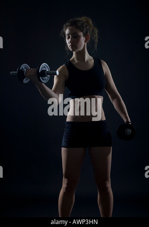 Young woman working out with dumbbells Banque D'Images