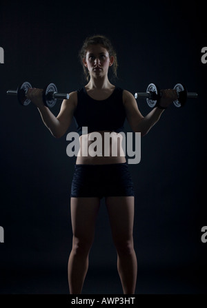 Young woman working out with dumbbells Banque D'Images