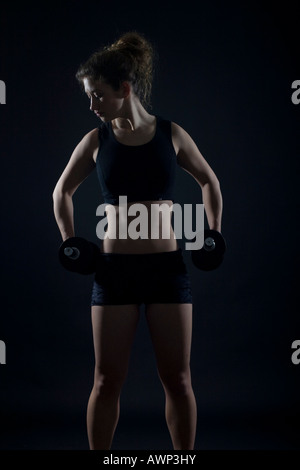 Young woman working out with dumbbells Banque D'Images