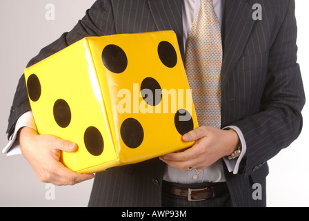 Business man holding big dice Banque D'Images