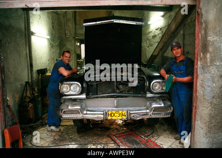 Deux mécaniciens travaillant dans leur garage, La Havane, Cuba, Caraïbes Banque D'Images
