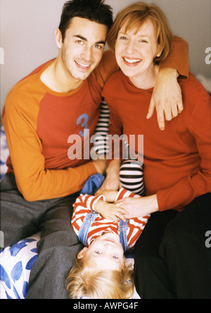 Enfant couché entre couple, portrait Banque D'Images