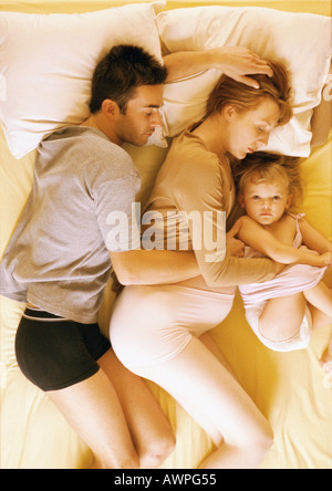 Homme, femme enceinte et l'enfant au lit, elevated view Banque D'Images