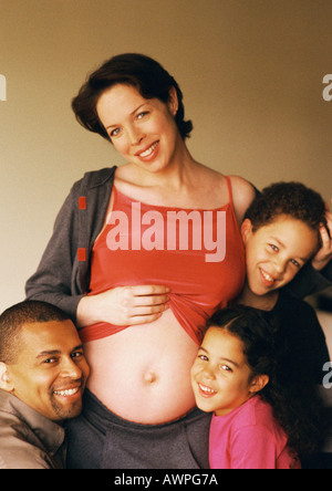 L'homme et des enfants autour de l'estomac de la femme enceinte exposée Banque D'Images