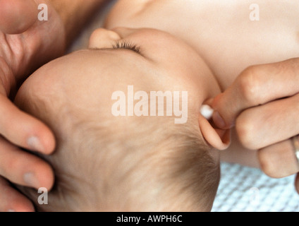 Après avoir nettoyé l'oreille de bébé avec du coton-tige, close-up Banque D'Images