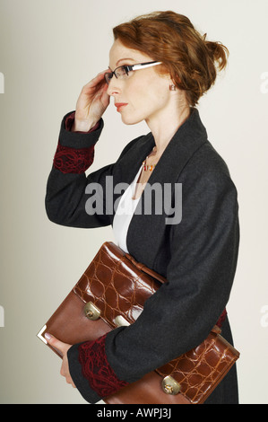 Businesswoman wearing eyeglasses holding briefcase Banque D'Images