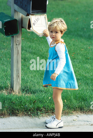 Girl standing in front de boîte aux lettres, à la caméra en Banque D'Images