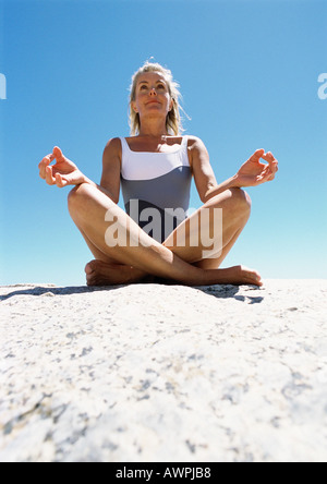 Femme méditant sur le sable. Banque D'Images