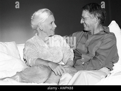 Senior couple holding hands on sofa, portrait Banque D'Images