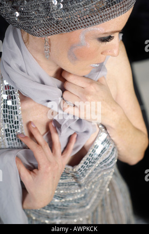 Jeune femme habillée d'une robe de soirée d'argent portant le chapeau et châle Banque D'Images