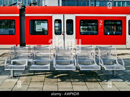 Chaises de passager sur une plate-forme en face de wagons de train urbain Banque D'Images