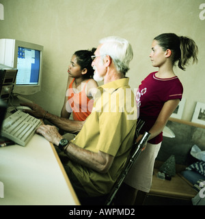 Homme mature et deux filles à l'aide d'ordinateur Banque D'Images