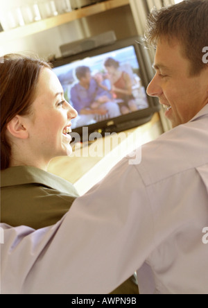 Couple côte à côte en face de la télévision, smiling, close-up, vue arrière Banque D'Images