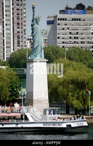 Statue de la liberté et un bateau Bateaux Mouches sur la Seine à Paris, France, Europe Banque D'Images