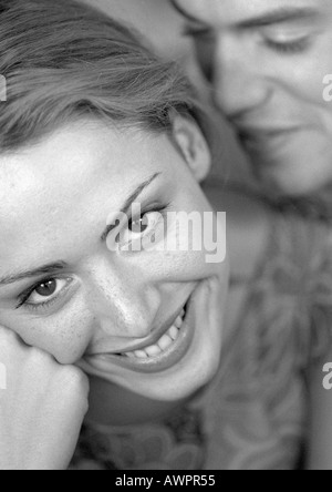 Homme debout derrière woman smiling, close-up, b&w Banque D'Images