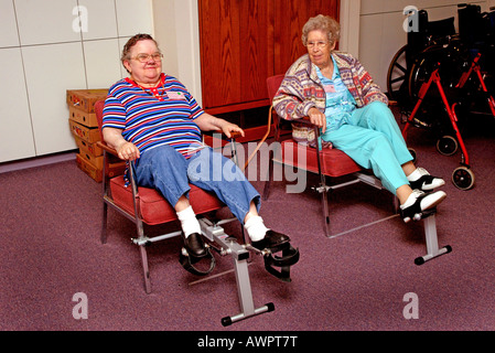 Deux femmes âgées, l'exercice sur les machines de la pédale au centre de jour Garden Grove California USA Model publié Banque D'Images