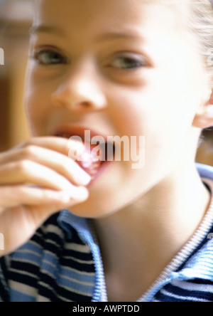 Young Girl eating strawberry, portrait. Banque D'Images