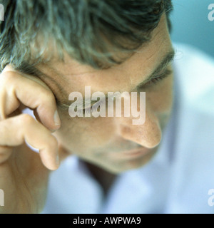 Man resting head contre part, yeux baissés, portrait Banque D'Images