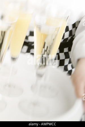 Waiter carrying tray de champagne, blurred motion, close-up Banque D'Images