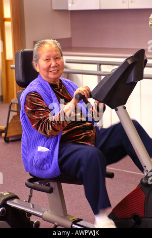Asian American hauts exercices avec la machine à pédale hauts day care centre Garden Grove California USA Model publié Banque D'Images
