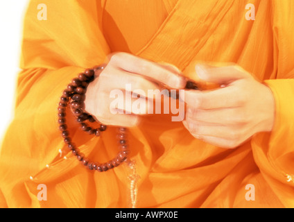 Le moine bouddhiste's hands holding prayer beads Banque D'Images