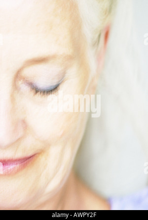 Senior woman smiling, oeil fermé, vue partielle de la face, close-up. Banque D'Images