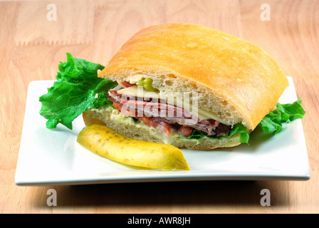 Sandwich sur une plaque blanche avec un cornichon Banque D'Images