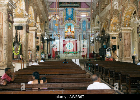 Les croyants solitaire assis dans la nef de ornate Basilique Santa Cruz. Fort Kochi, fort Cochin, Kerala, Inde du Sud. Banque D'Images