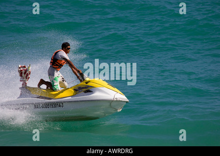 Jeune homme à cheval sur les genoux de Jet Ski Banque D'Images