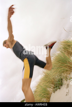 Jeune homme sur le saut de plage,. Banque D'Images