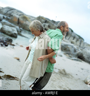 Mature couple debout dos à dos, bras verrouillé, side view Banque D'Images