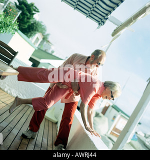 D'âge mûr jouant sur le pont de beach house Banque D'Images