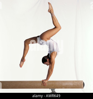 Jeune gymnaste sur poutre d'effectuer, side view Banque D'Images