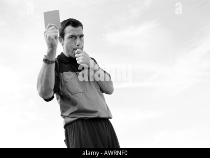 Répondant en match de foot holding up card, b&w. Banque D'Images