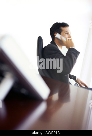 Businessman using phone, side view Banque D'Images